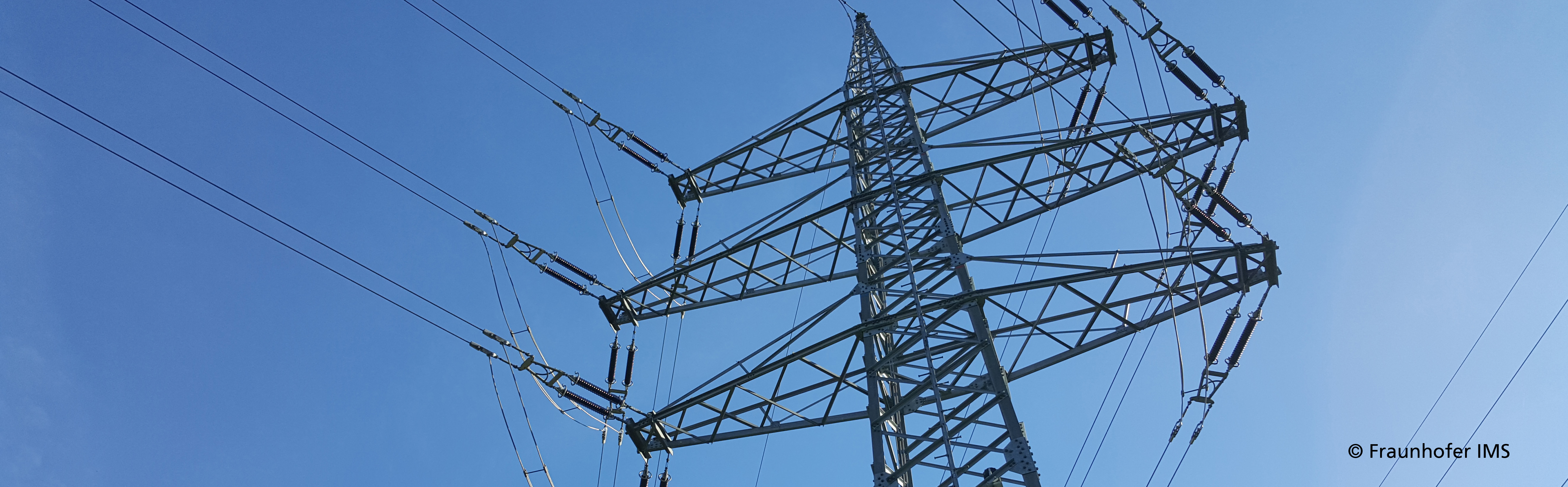 Bild von einem Strommasten vor blauem Himmel