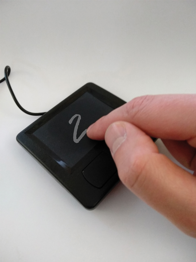 Abbildung eines Touchpads auf das mit dem Finger eine Zahl gezeichnet wird.