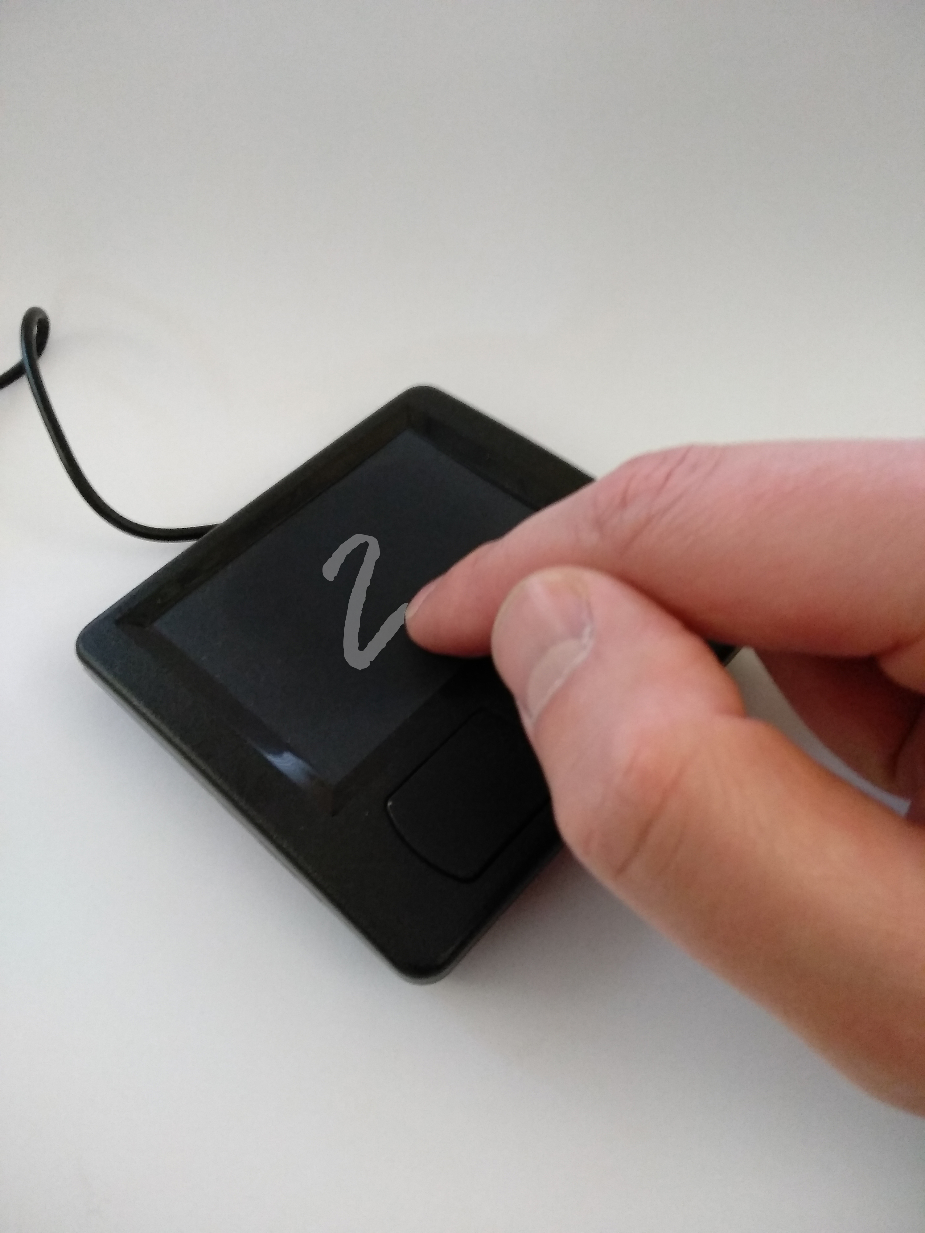 Image of a touchpad on which a digit is written with a finger.